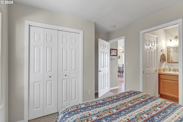 carpeted bedroom featuring ensuite bathroom and a closet