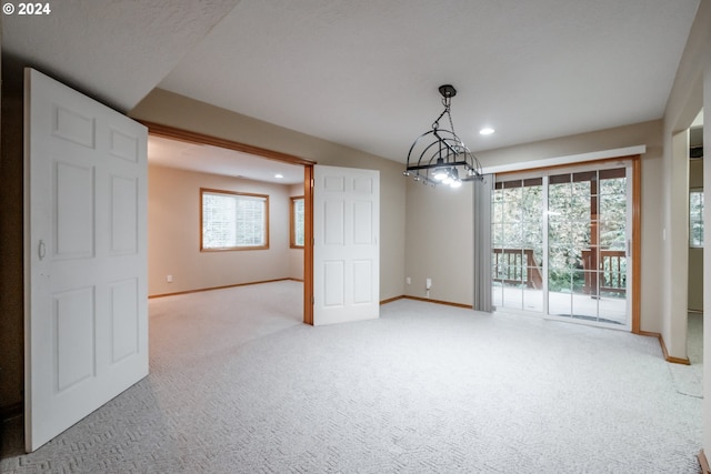 unfurnished dining area featuring an inviting chandelier and carpet flooring