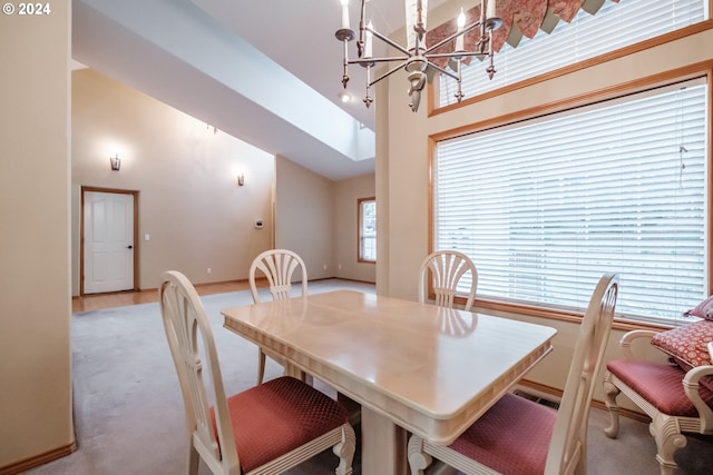 dining space featuring a notable chandelier, light carpet, and high vaulted ceiling