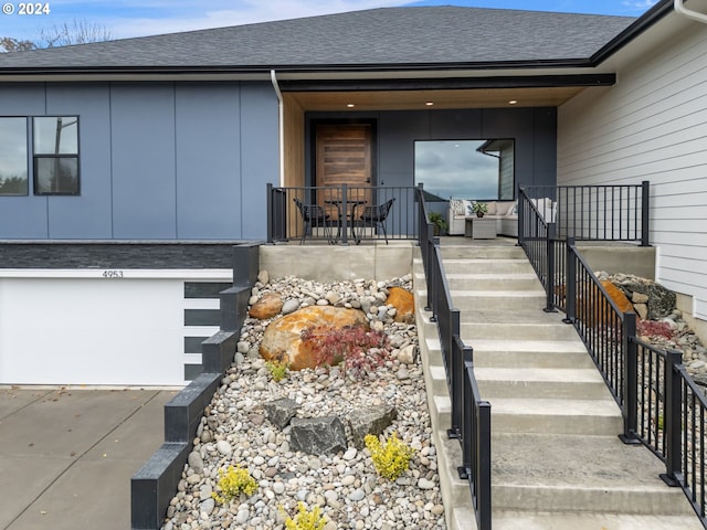 doorway to property featuring covered porch and a garage