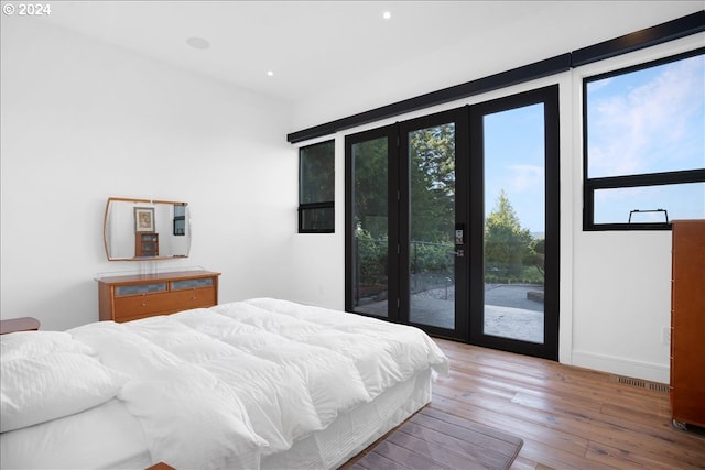 bedroom featuring french doors, access to exterior, and light hardwood / wood-style flooring