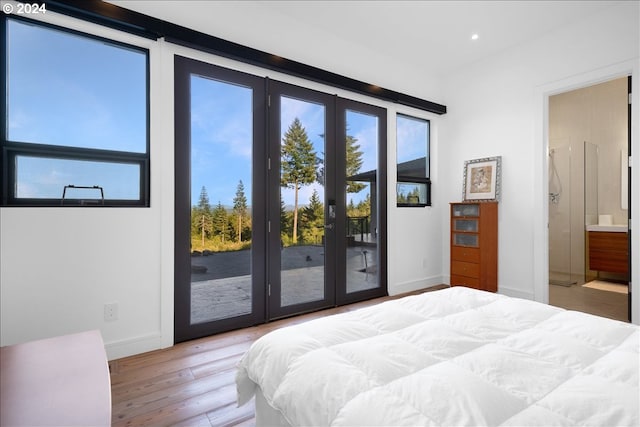 bedroom featuring access to outside, french doors, ensuite bathroom, and light wood-type flooring