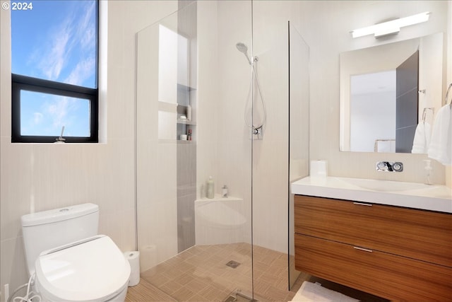 bathroom featuring toilet, vanity, a shower with shower door, and tile flooring