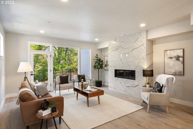 living room featuring a high end fireplace and hardwood / wood-style floors