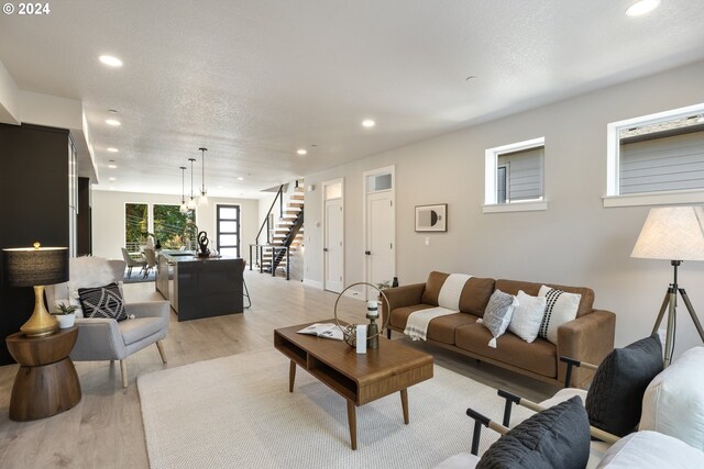 living room featuring a textured ceiling and light wood-type flooring