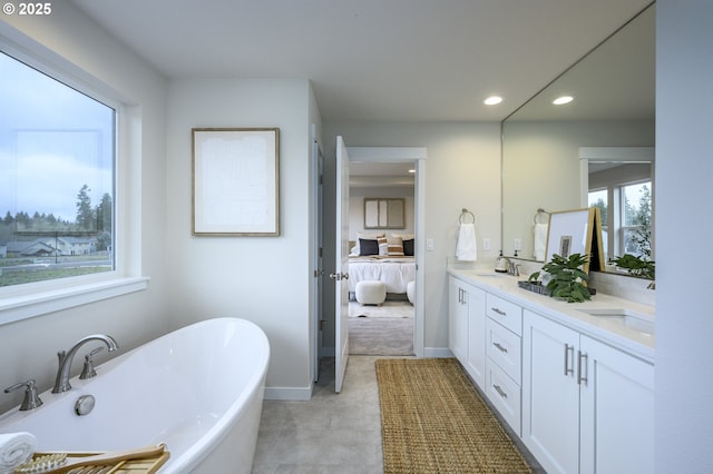 ensuite bathroom featuring a sink, a soaking tub, ensuite bath, and recessed lighting