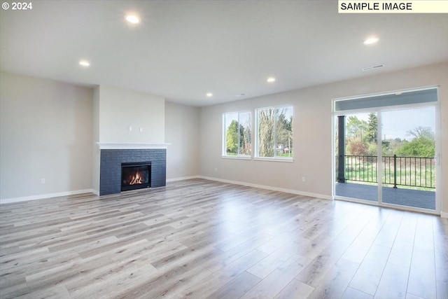 unfurnished living room featuring a wealth of natural light and light hardwood / wood-style floors