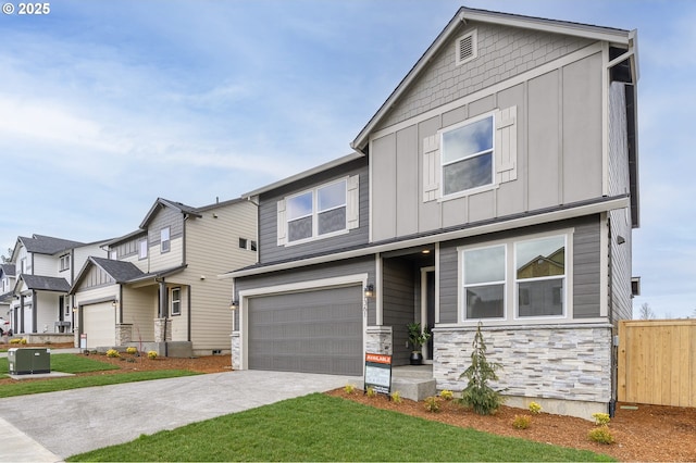 view of front of house featuring fence, driveway, an attached garage, central AC, and board and batten siding