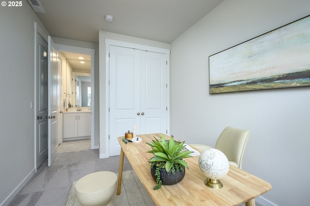 home office featuring visible vents, light carpet, and baseboards