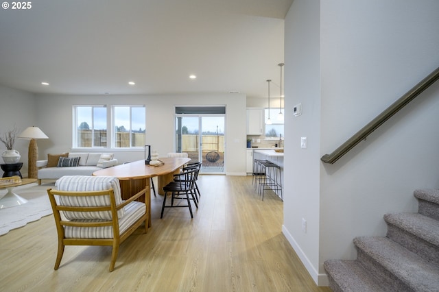 living area with stairs, recessed lighting, light wood-style floors, and baseboards