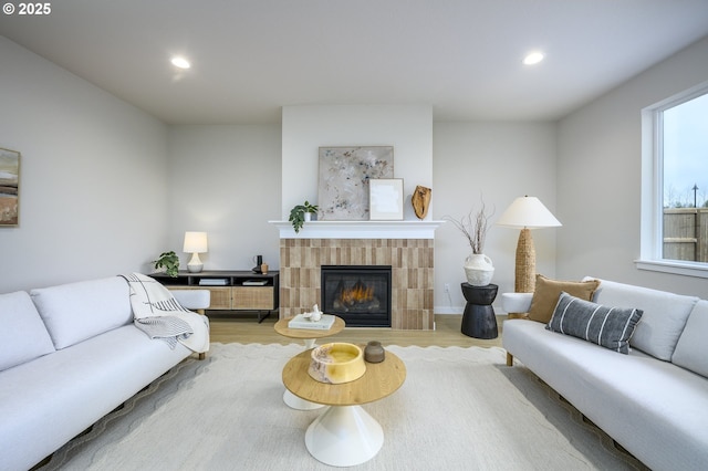 living area with recessed lighting, wood finished floors, and a tile fireplace