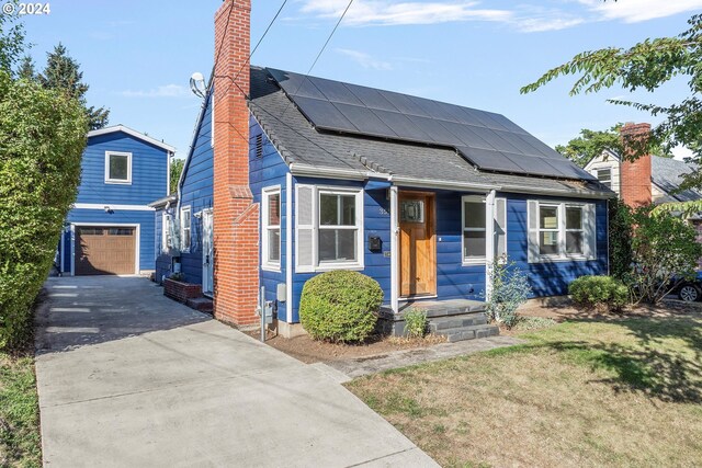 view of front of home with a front yard, a garage, and solar panels