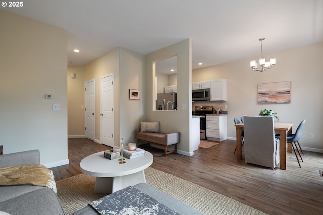 living room featuring dark hardwood / wood-style flooring and an inviting chandelier