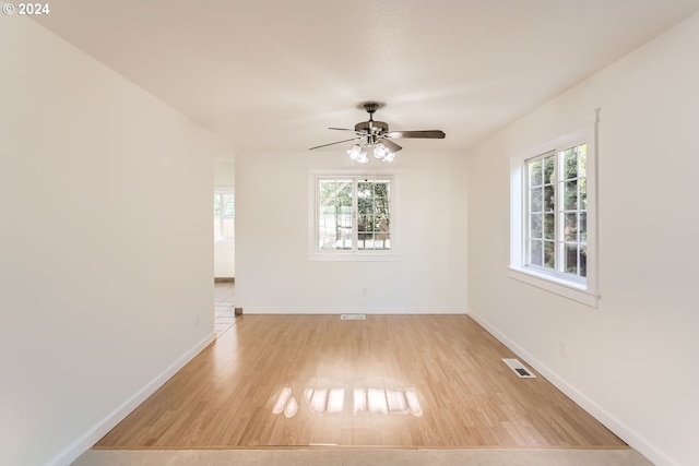 empty room featuring visible vents, baseboards, and wood finished floors