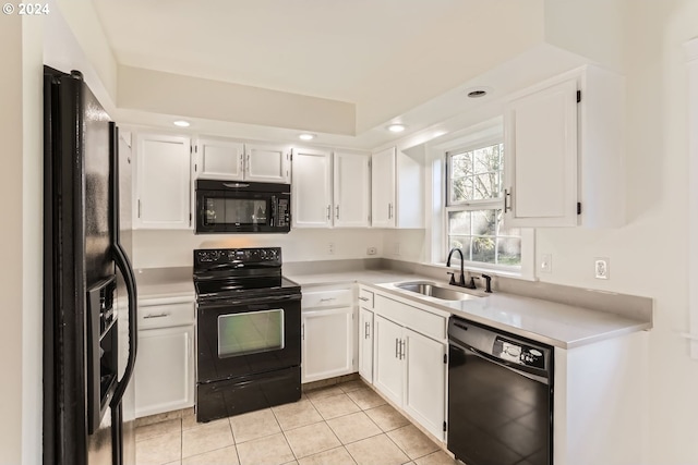 kitchen featuring white cabinets, a sink, and black appliances