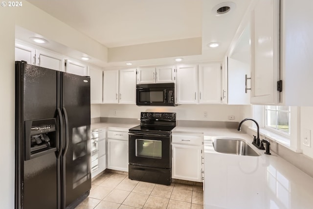 kitchen with light tile patterned floors, white cabinets, light countertops, black appliances, and a sink