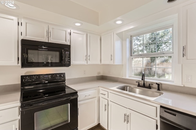 kitchen featuring black appliances, white cabinets, a sink, and light countertops