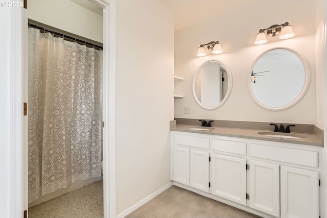 bathroom with double vanity, a sink, and baseboards