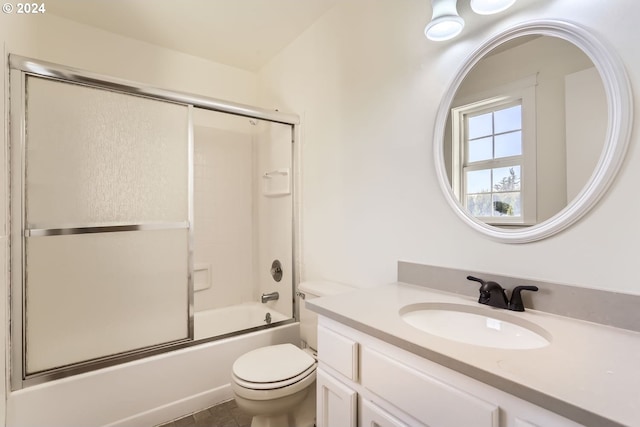 bathroom with toilet, bath / shower combo with glass door, and vanity