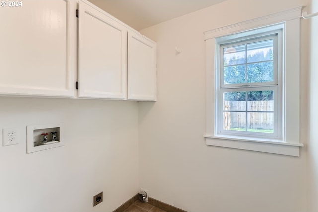 laundry room with cabinet space, baseboards, hookup for a washing machine, dark tile patterned floors, and electric dryer hookup