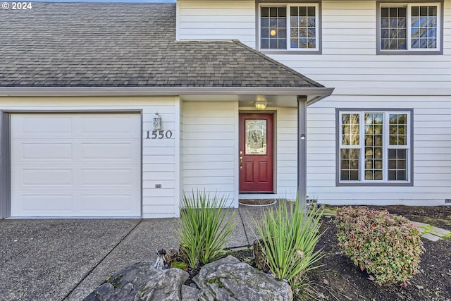 doorway to property with a shingled roof