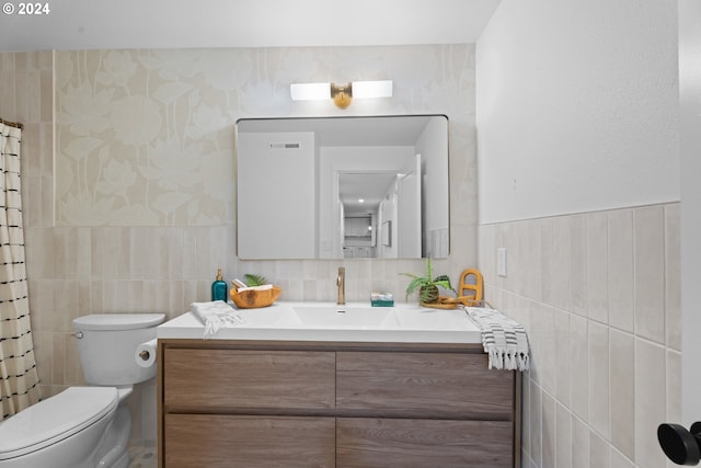 bathroom with toilet, vanity, tile walls, and a shower with shower curtain