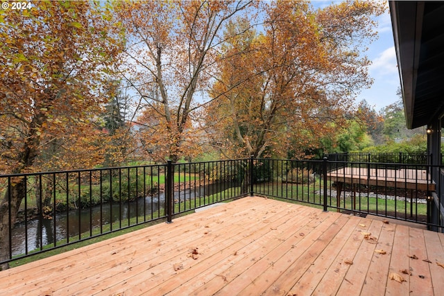 wooden terrace featuring a water view