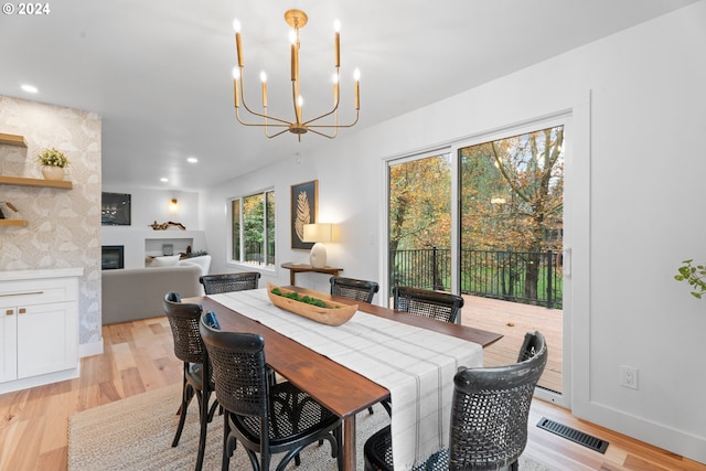 dining space with light wood-type flooring and a notable chandelier