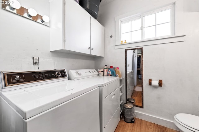 clothes washing area with light wood-type flooring, washing machine and dryer, and laundry area