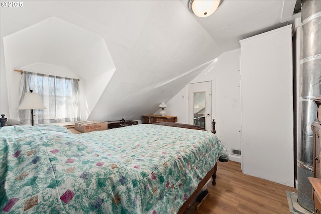 bedroom featuring lofted ceiling and wood finished floors