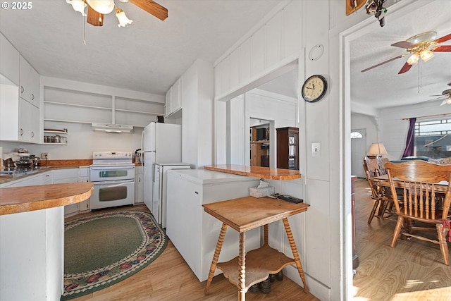 kitchen with light wood finished floors, light countertops, white appliances, and white cabinetry