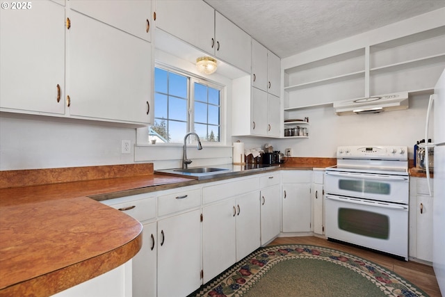 kitchen with extractor fan, a sink, white cabinets, and double oven range