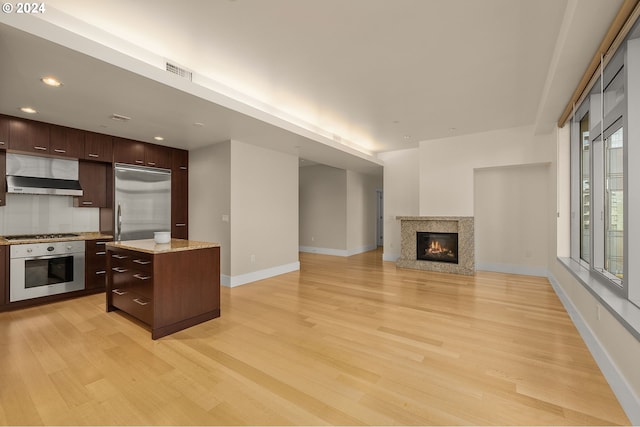 kitchen featuring dark brown cabinets, appliances with stainless steel finishes, light wood-type flooring, and a kitchen island