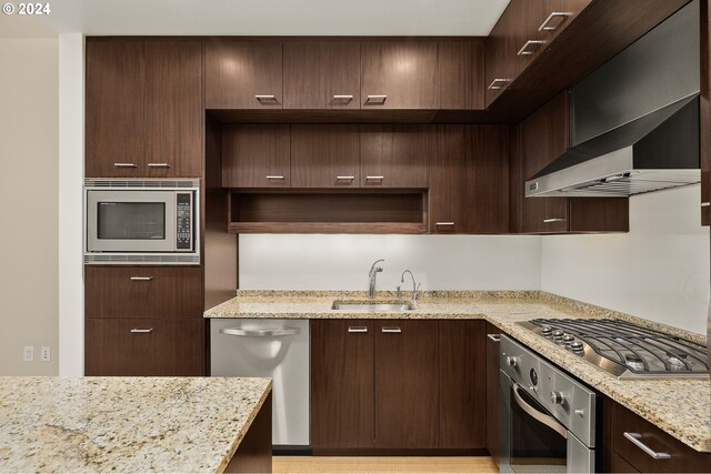 kitchen with dark brown cabinets, light stone countertops, stainless steel appliances, and sink