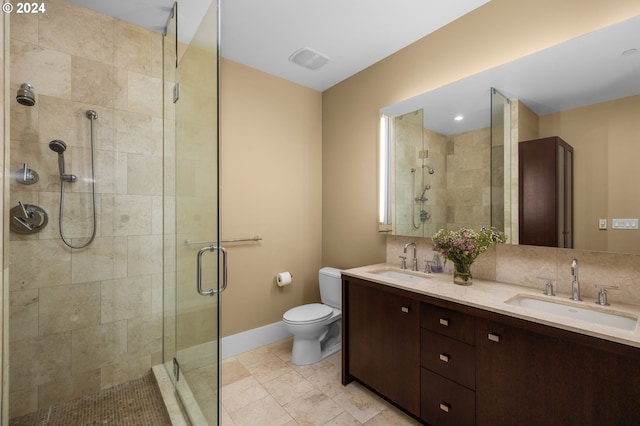 bathroom with backsplash, a shower with door, toilet, and vanity