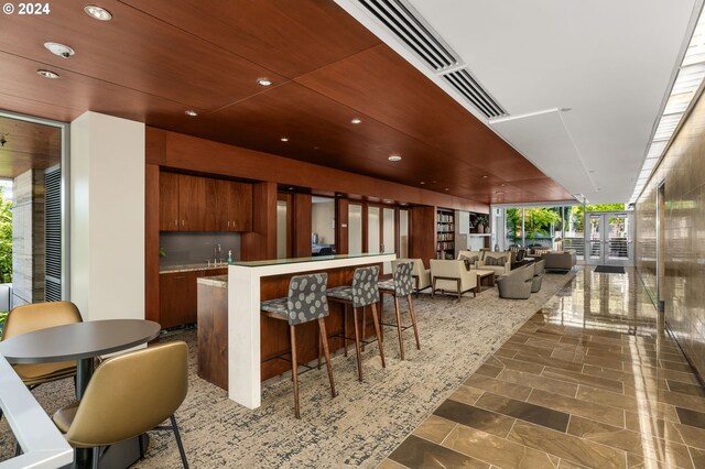 kitchen featuring a kitchen breakfast bar, a healthy amount of sunlight, sink, and expansive windows