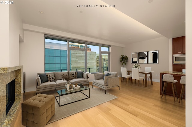 living room with light wood-type flooring and a fireplace