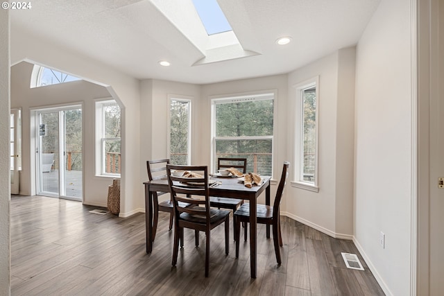 dining area featuring dark hardwood / wood-style flooring, a textured ceiling, and a wealth of natural light