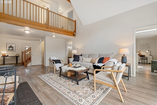 living room featuring wood-type flooring and high vaulted ceiling