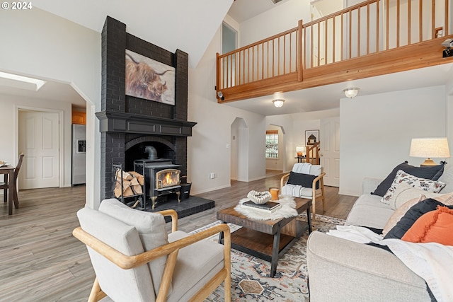 living room featuring a wood stove, hardwood / wood-style floors, and high vaulted ceiling