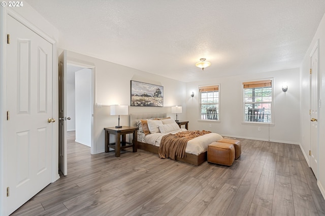 bedroom featuring hardwood / wood-style flooring and a textured ceiling