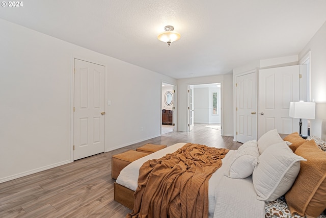 bedroom with light hardwood / wood-style floors and a textured ceiling