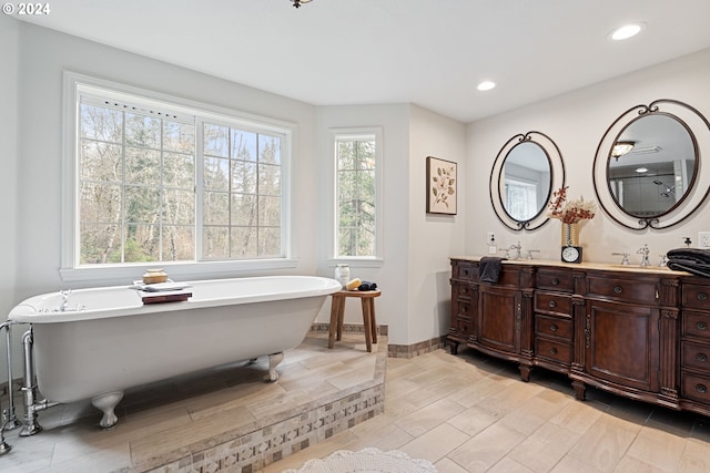 bathroom with a tub to relax in and vanity