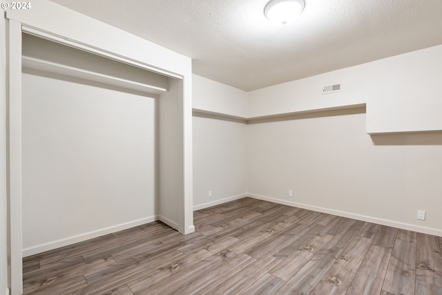 empty room featuring wood-type flooring and a textured ceiling