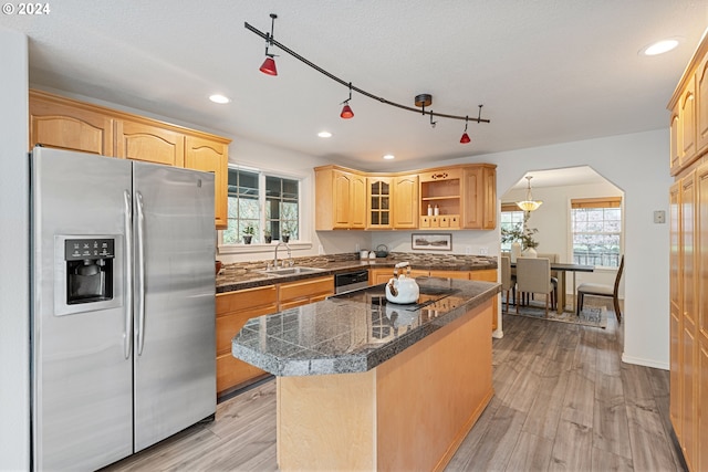 kitchen featuring light hardwood / wood-style flooring, a kitchen island, stainless steel appliances, and plenty of natural light