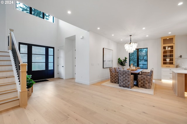 foyer entrance with light hardwood / wood-style flooring and an inviting chandelier