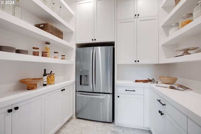 kitchen featuring white cabinetry and stainless steel refrigerator with ice dispenser