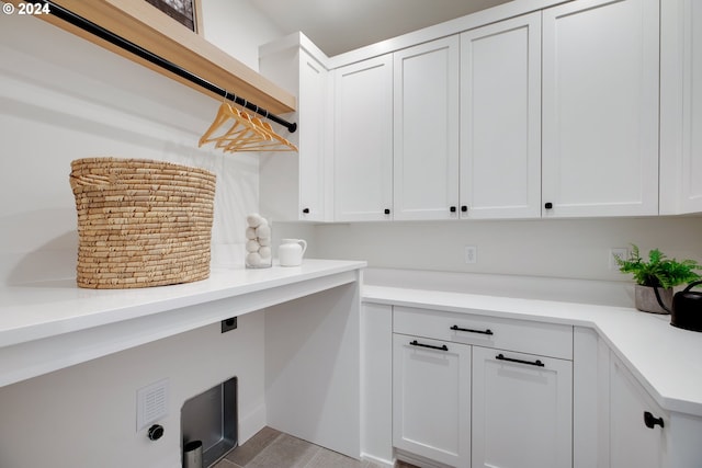 laundry area with light hardwood / wood-style flooring, cabinets, and electric dryer hookup