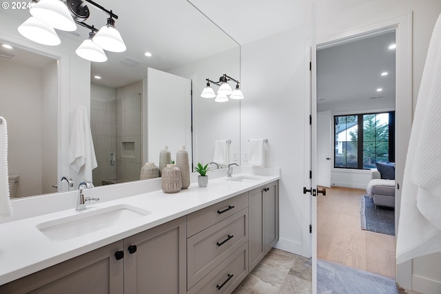 bathroom with toilet, vanity, a chandelier, hardwood / wood-style flooring, and a shower with shower door