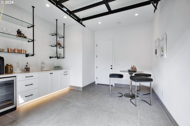 bar with wine cooler and white cabinetry